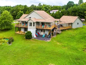 +4 acre lakefront retreat with private boat slip, wraparound porch, grill, & W/D
