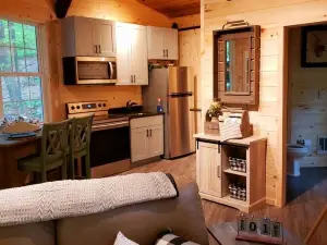 The Chalet is located in the woods of a gated property with a covered porch.