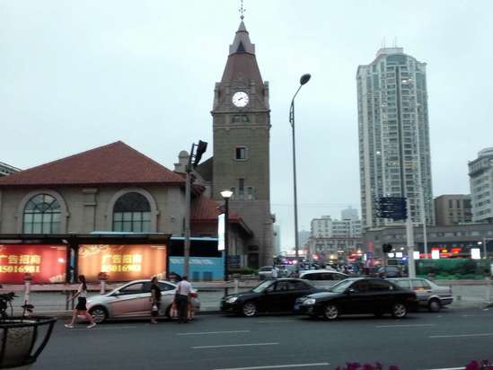 青岛火车站位于青岛市中心,距离海边仅两百多米。这是一组建于1899年的德国文艺复兴风格建筑,它拥有醒目的红瓦黄墙,以及一座尖顶的钟楼,外形很漂亮也很文艺。青岛火车站至今仍在使用,是青岛的地标建筑之一。 青岛火车站主要由钟楼和候车大厅两大部分组成。它是由德国人魏尔勒和格德尔茨设计的,这坐火车站再现了设计师家乡的建筑风格,尤其是35米高的车站钟楼,更是沿用了德国乡间教堂样式。一百多年间,车站钟楼上行走的时钟一刻不停地记录了那些行色匆匆的旅客们。